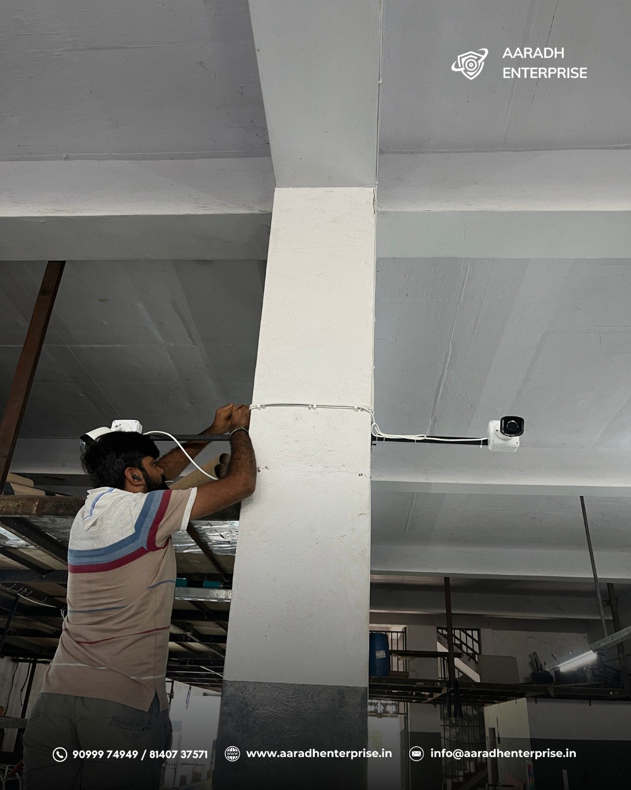 Technician installing CCTV camera in factory